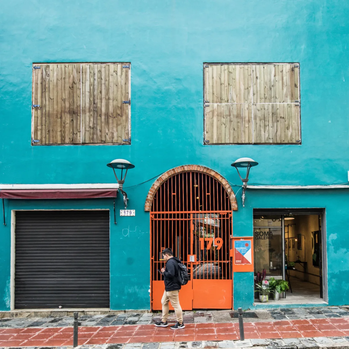 Atrás do portão laranja se “esconde”um refúgio urbano, onde o único barulho são os sinos da catedral de Curitiba.