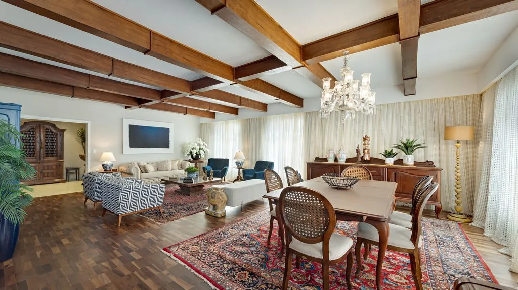 Na sala de jantar, o estilo
clássico é marcante pelo piso de taco e vigas de madeira no teto, originais do prédio, junto ao
mobiliário de herança da família.